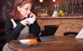 businesswoman-looking-tablet-while-talking-having-conversation-her-phone-working-vintage-coffee-shop_482257-25756