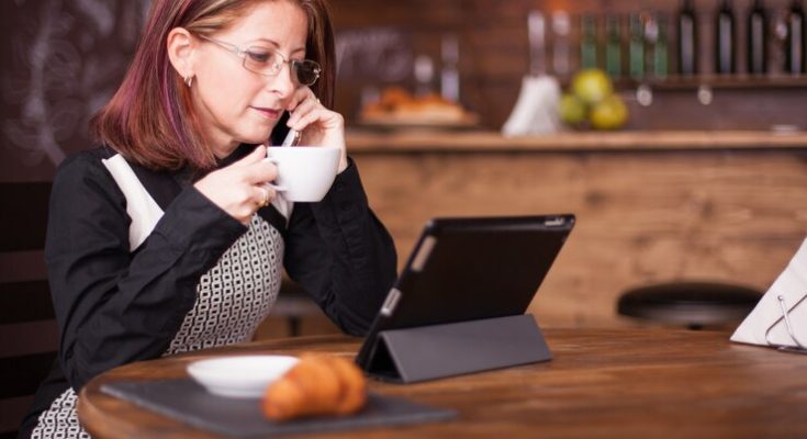 businesswoman-looking-tablet-while-talking-having-conversation-her-phone-working-vintage-coffee-shop_482257-25756